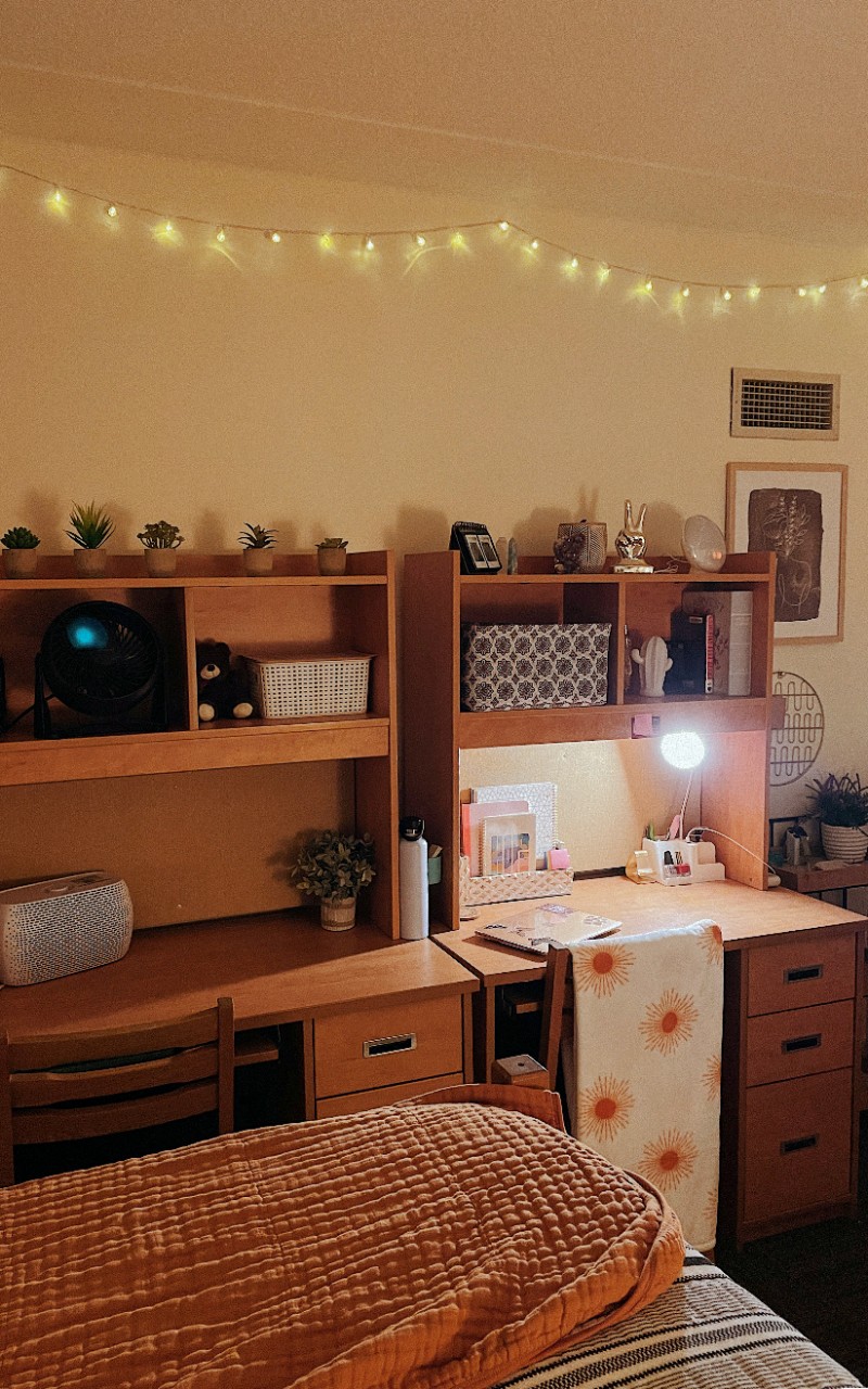 Two desks are arranged next to each other with wall decorations above. 