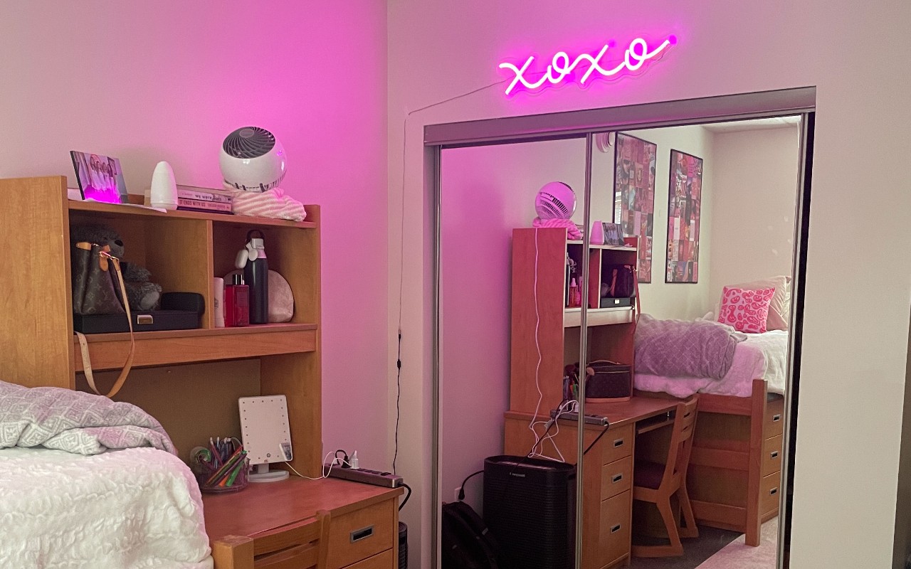 UPA dorm bedroom decorated with pink LED lights and a full body mirror