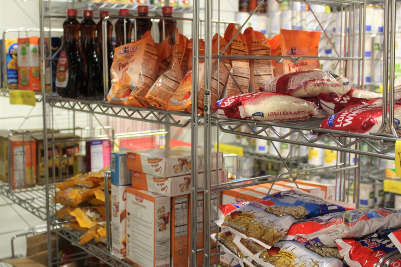 A rack of shelves with groceries, including rice and syrup