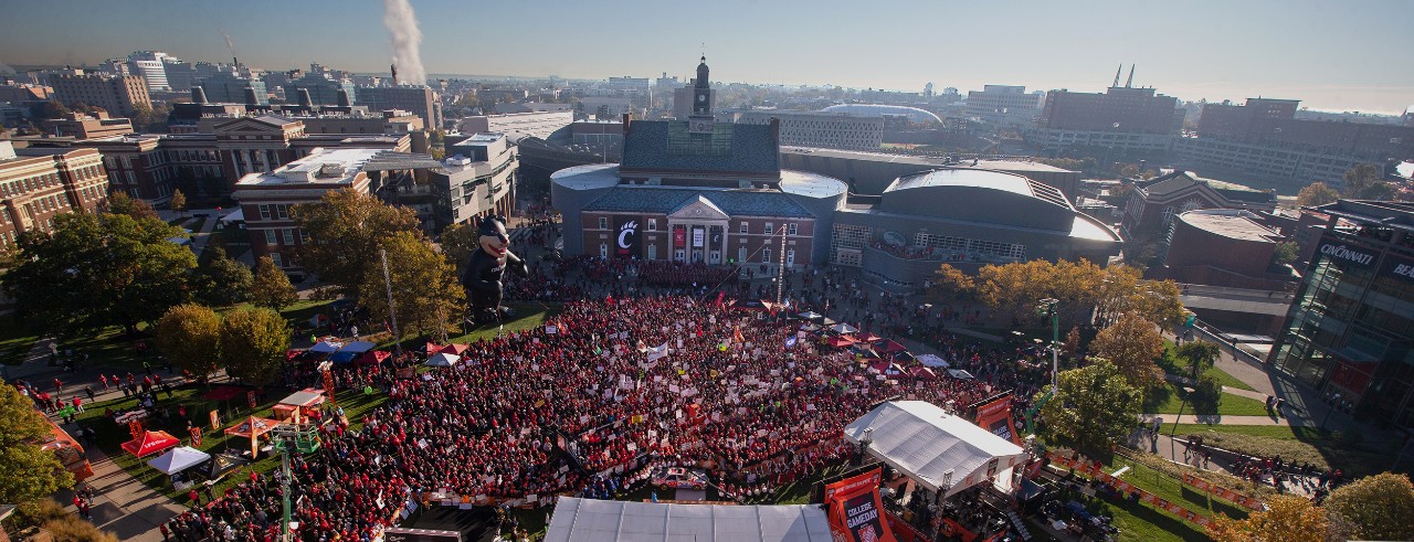 The roof and tower of Tangeman University Center are silhoutted against an orange sunset