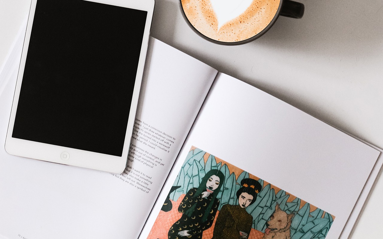 An iPad lays on top of a textbook.