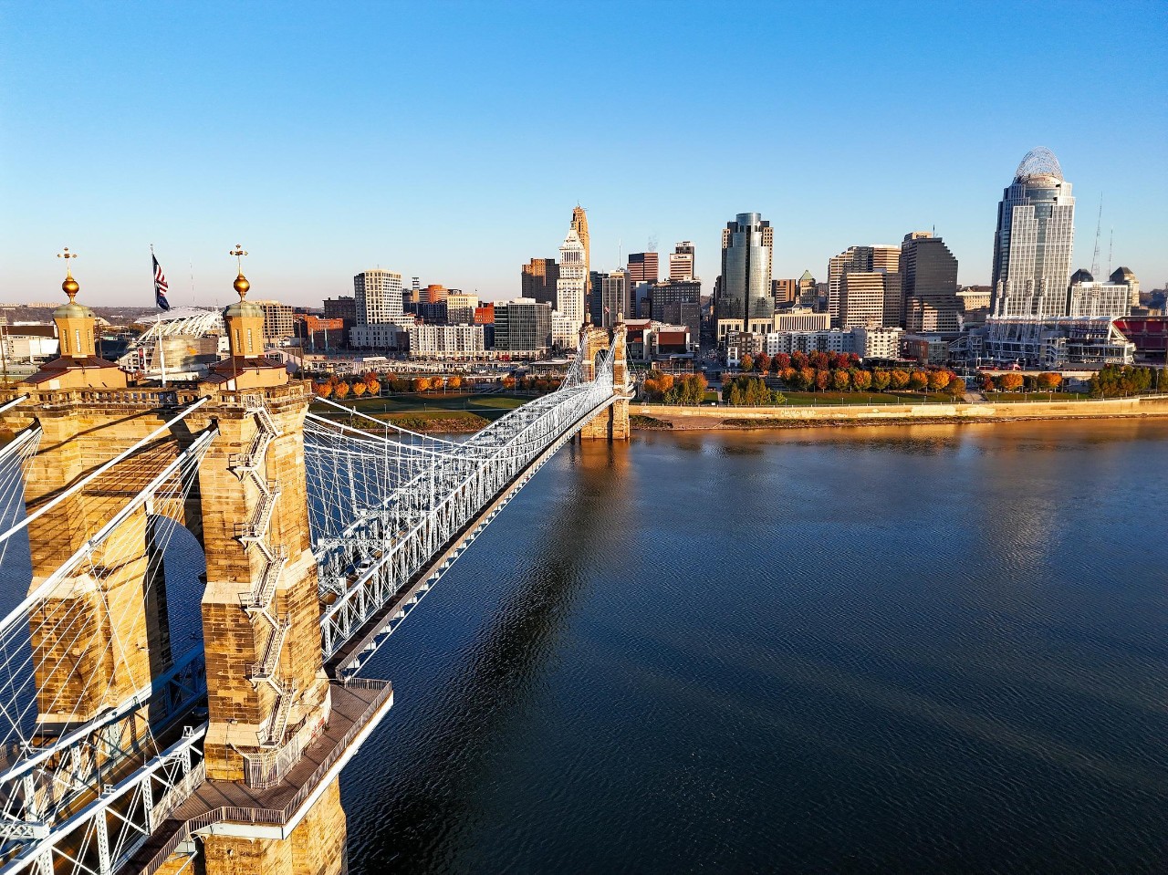 An aerial view of the Roebling Suspension Bridge with the Cincinnati Skyline in the background