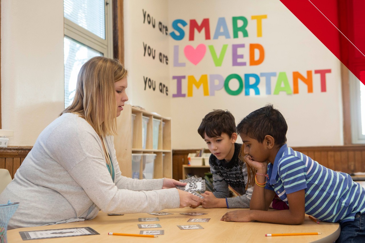 CANS teacher Maggie Luken works with a small group of students on a reading activity. 