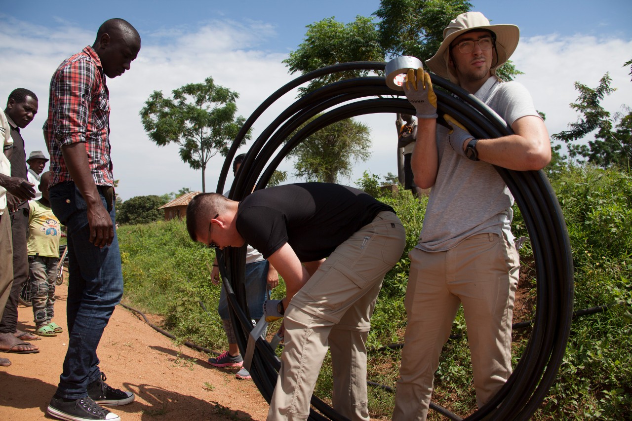 UC's Engineers Without Borders work on a water project in Tanzania while carrying pipe