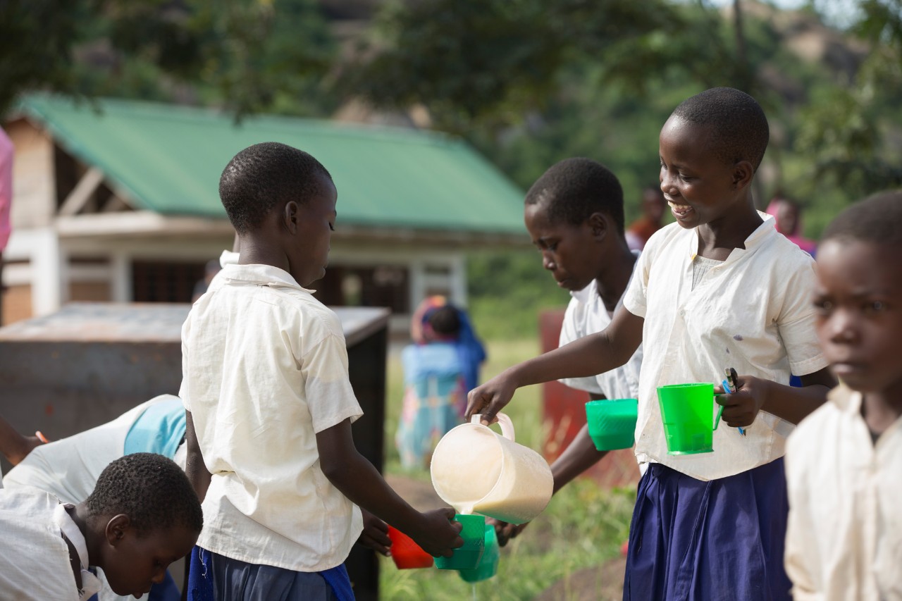 Students pour Uji, a pouridge into a cup