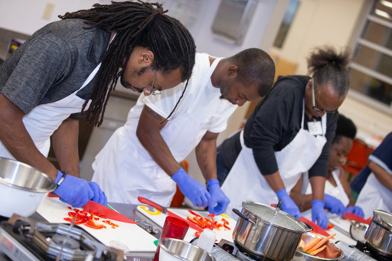 Students prepare vegetables during a cooking class