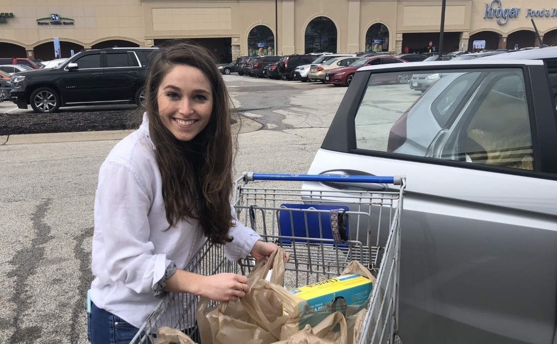 A UC student unloads groceries from a cart