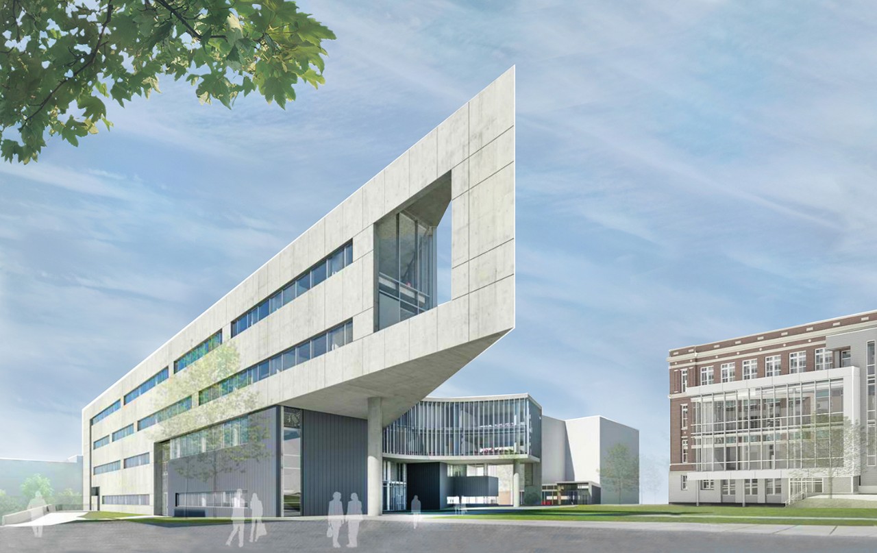 A rendering of the new Health Sciences Building. The four-story building facade is a stone-like material with glass windows. It comes to a sharp point.