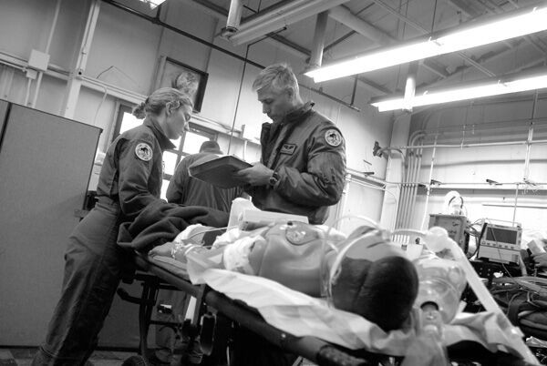 Black and white photo of trauma care team working on a medical dummy