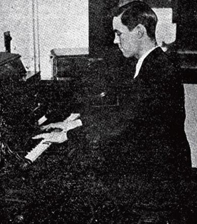 Black and white photo of a man playing organ