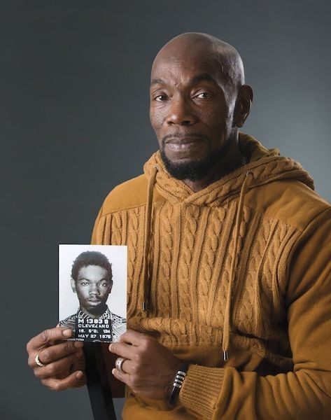 Ohio Innocence Project exoneree holding a photo of his mugshot
