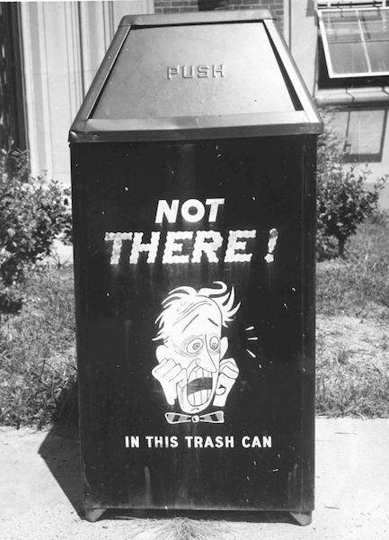 Black and white photo of a trash can that read, " Not There! In this trash can."