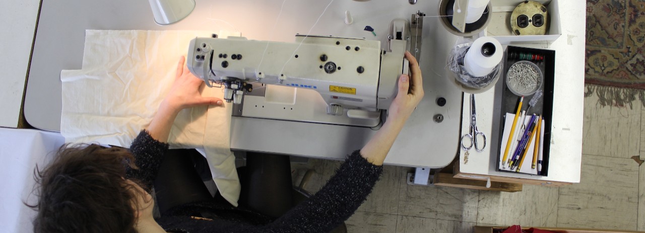 A view from above of a person operating a sewing machine.