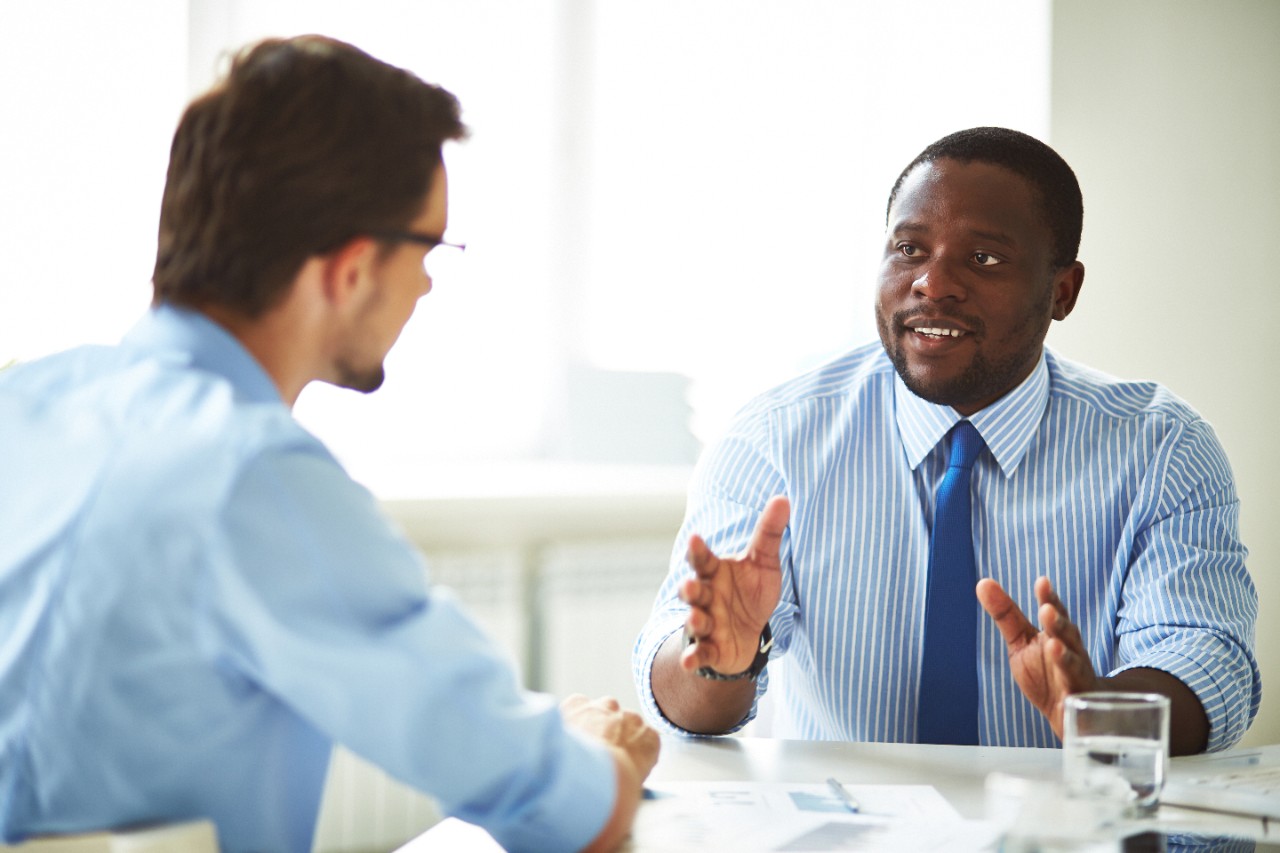 two business men have a table discussion