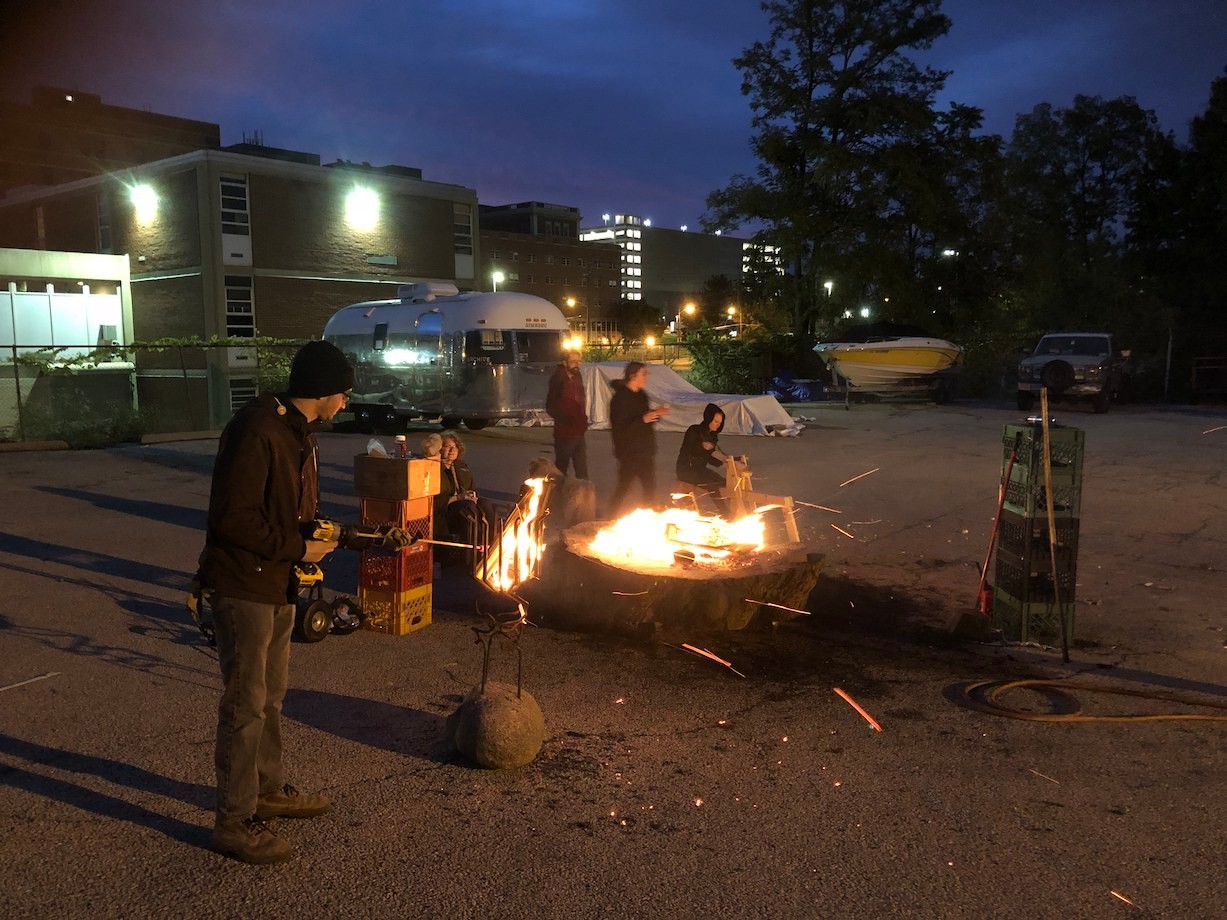 Students work in the dark around a fire