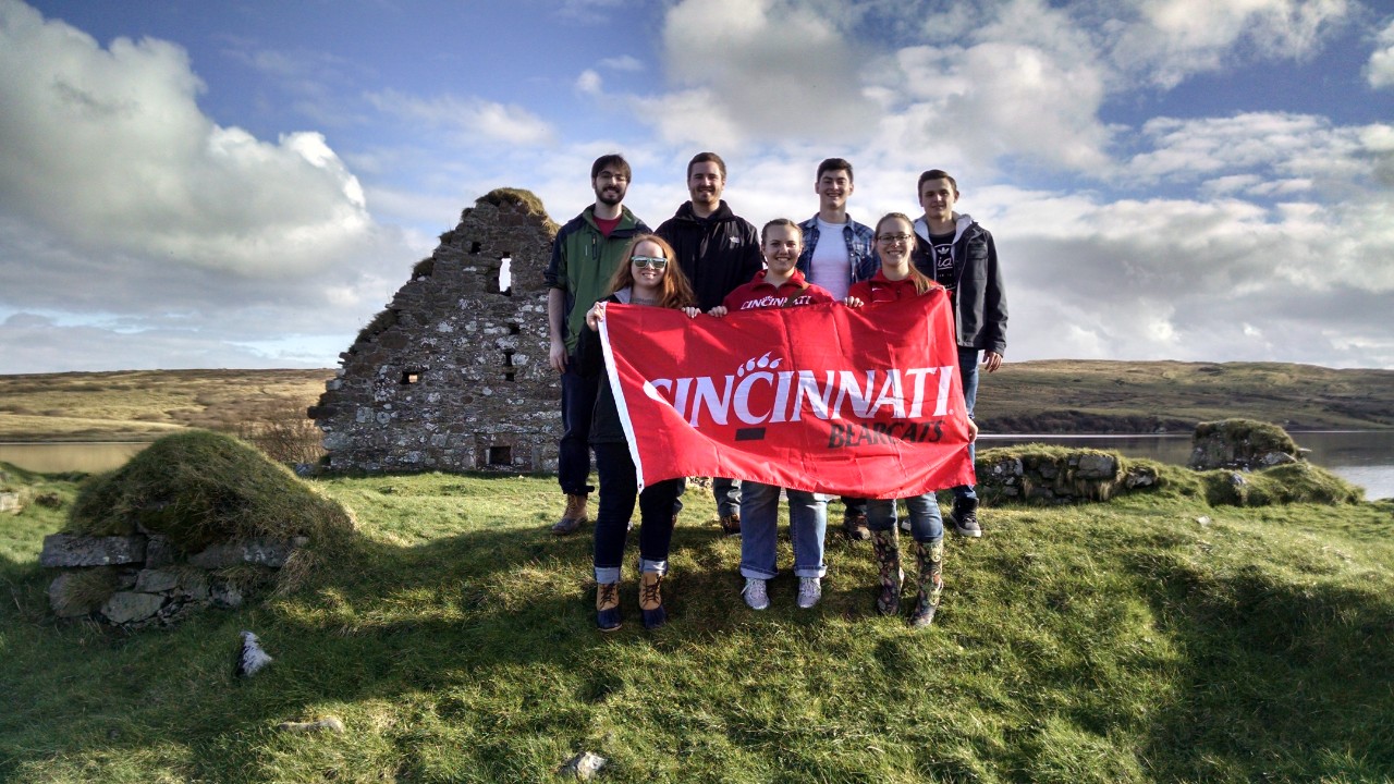 faculty led group abroad holds a UC banner