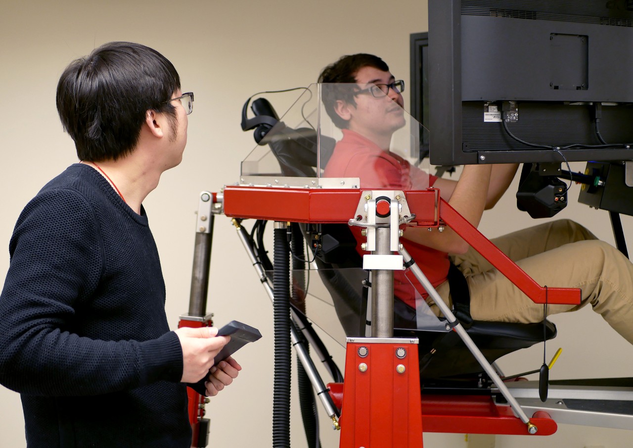 Ma instructs his student in the driving simulator