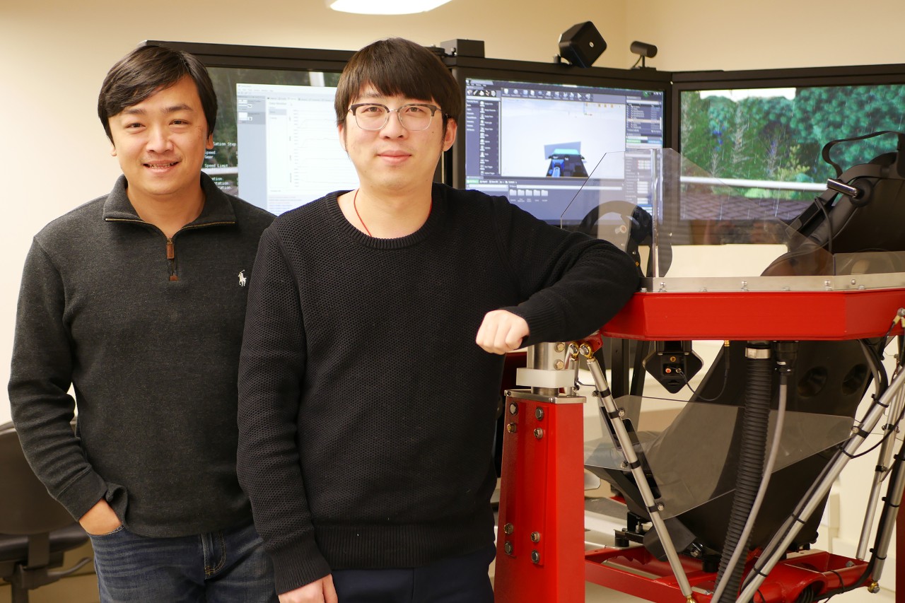 Ma and Wang pose next to driver simulator