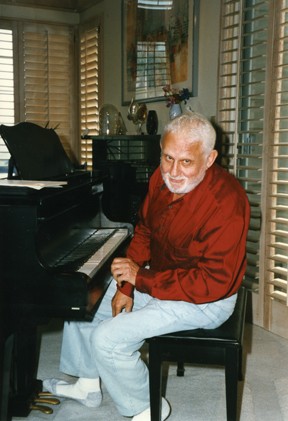 UC Alumnus Albert Hague sits at his piano
