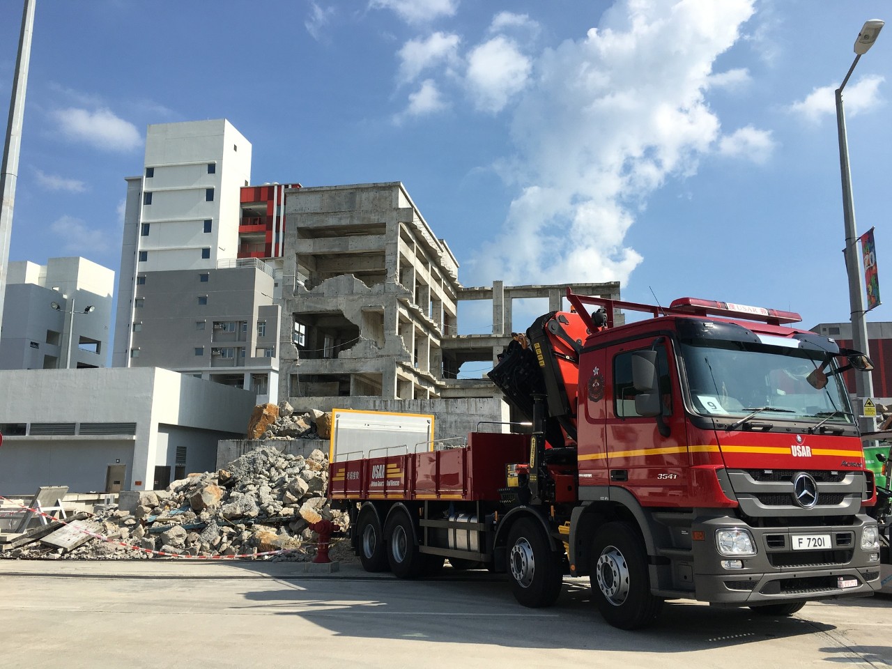 firetruck with building damaged by earthquake in background