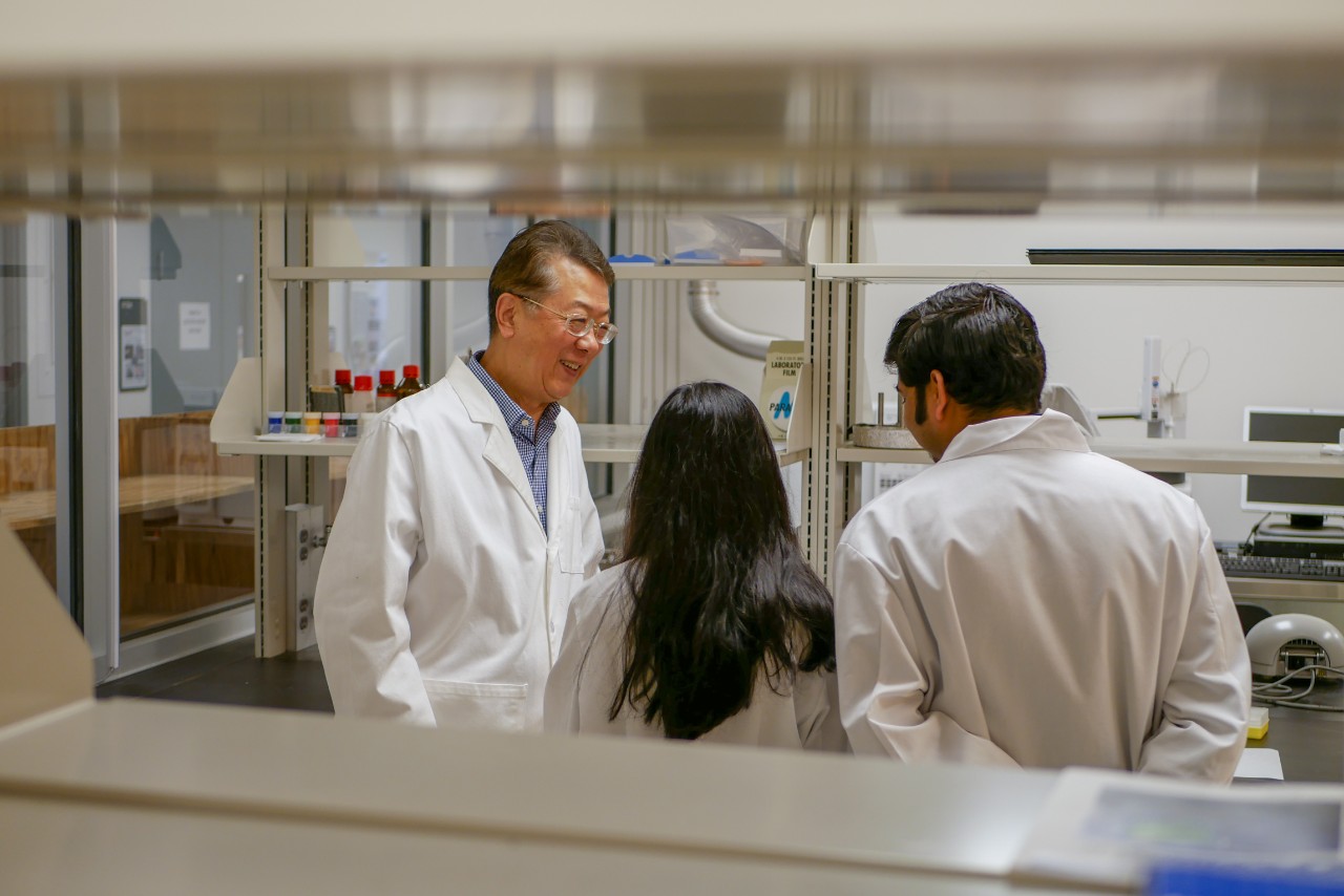 Ahn in lab talking to two grad students