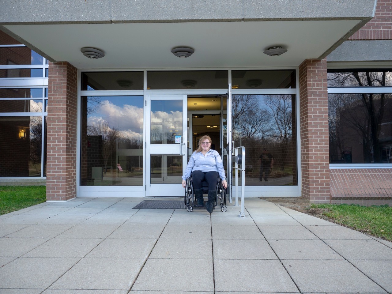 student in wheelchair in front of building