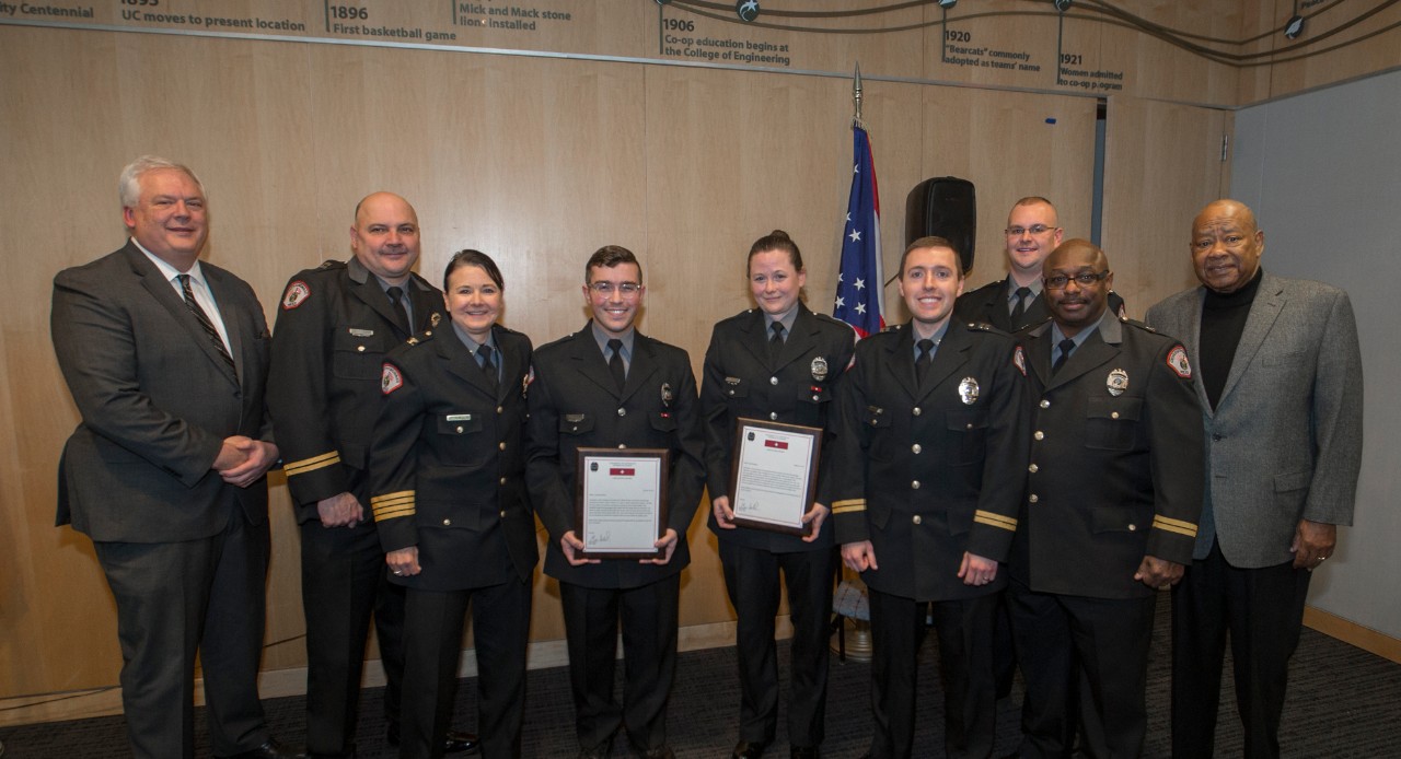 Officers Kennerly Newlin and Laura Hutchings stand with members of UCPD and the community after being recognized on Feb. 28, 2019, for saving a student's life.