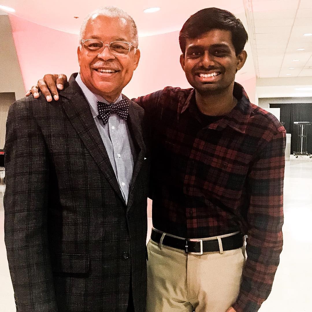 Arunkumar Muthusamy poses for a photo with his hand on Eric Abercrumbie's shoulder.