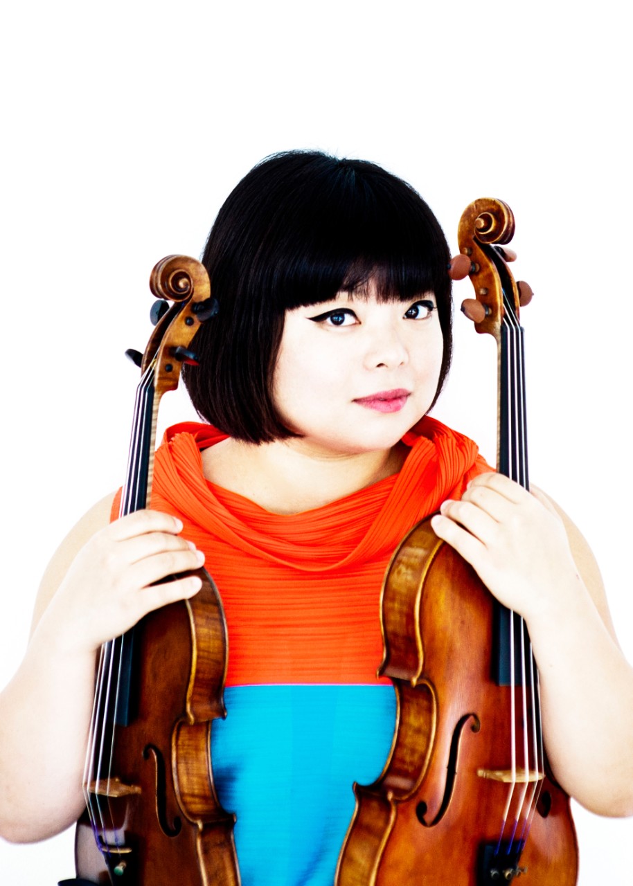A photograph of CCM guest artist Yura Lee holding a violin and viola.
