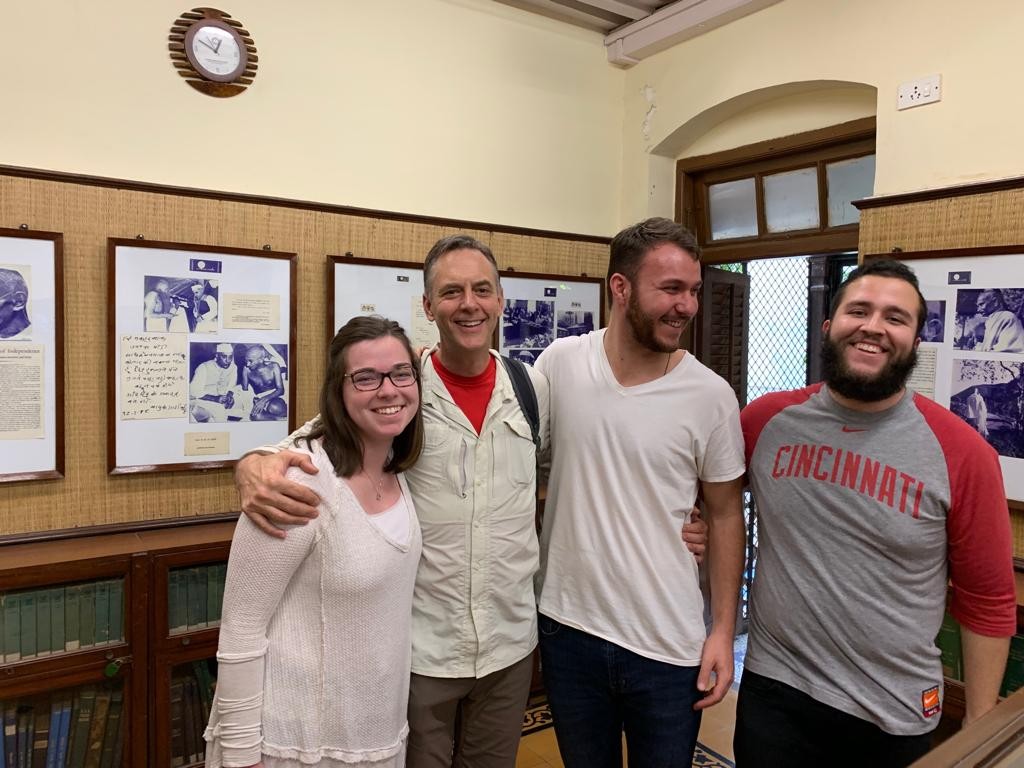 Man with two male students, one female student
