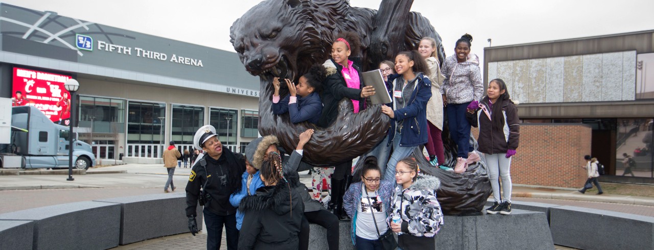 Student from 9th District Covington school posed for a photo with the Bearcat Statue with Fifth Third Arena in the background. UC/Joseph Fuqua II

