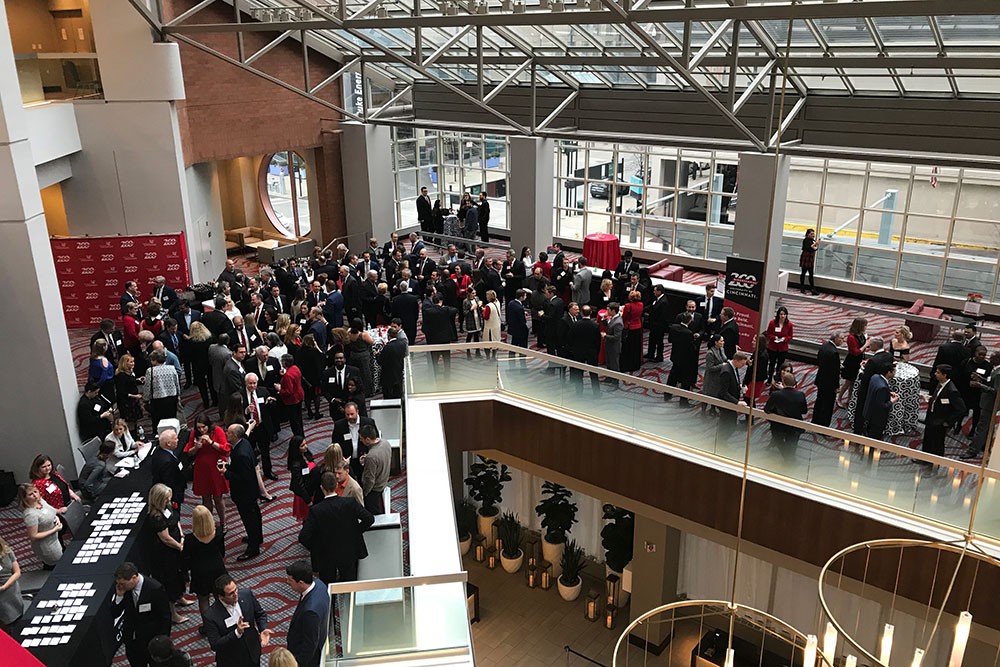 A wide shot of the reception area at the business awards, with about 100 guests visible mingling