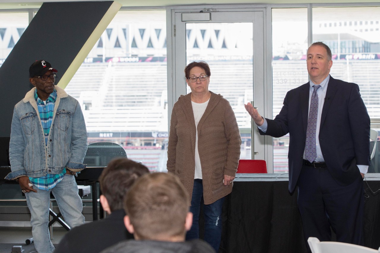 Nancy Smith, an OIP exoneree stands between three other recent exonerees in UC's Nippert Stadium.