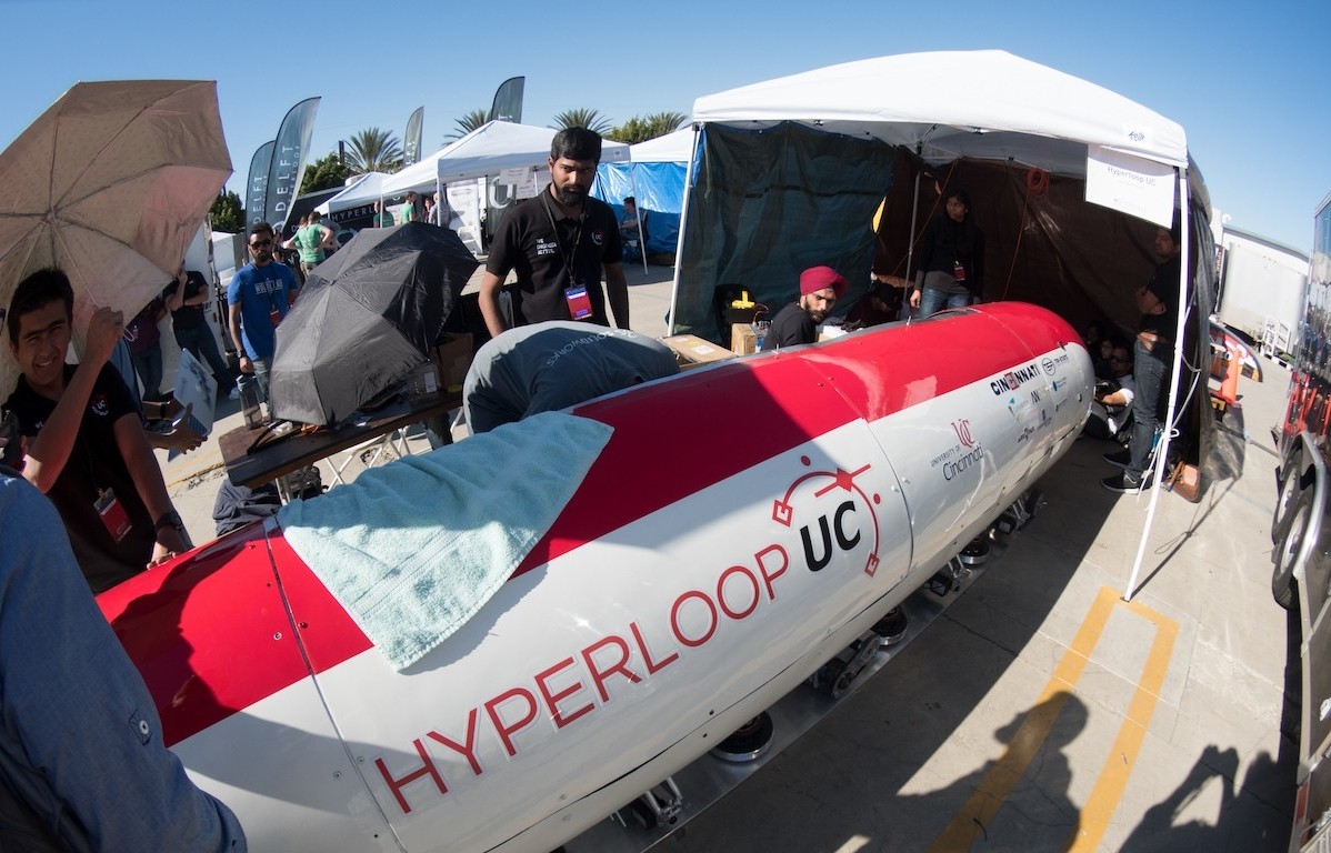 UC students huddle around a hyperloop pod in the California sun.