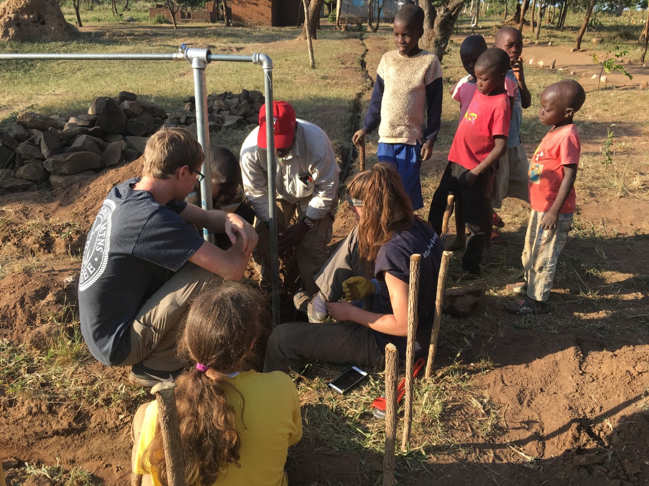 students working on water pipe