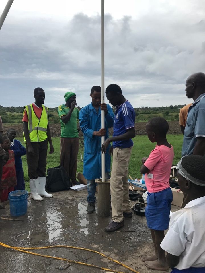 people inserting water piping into ground