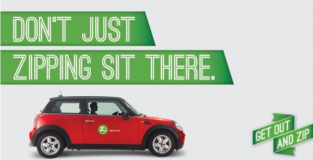 Small red car with ZipCar banner on top.