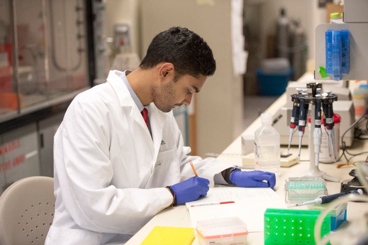 Rahul Sandella, Presidential Leadership Medal of Excellence awardee, in lab and in CARE atrium.