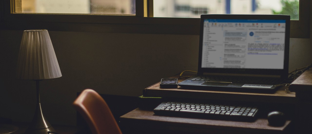 Computer sitting on a desk displays email program