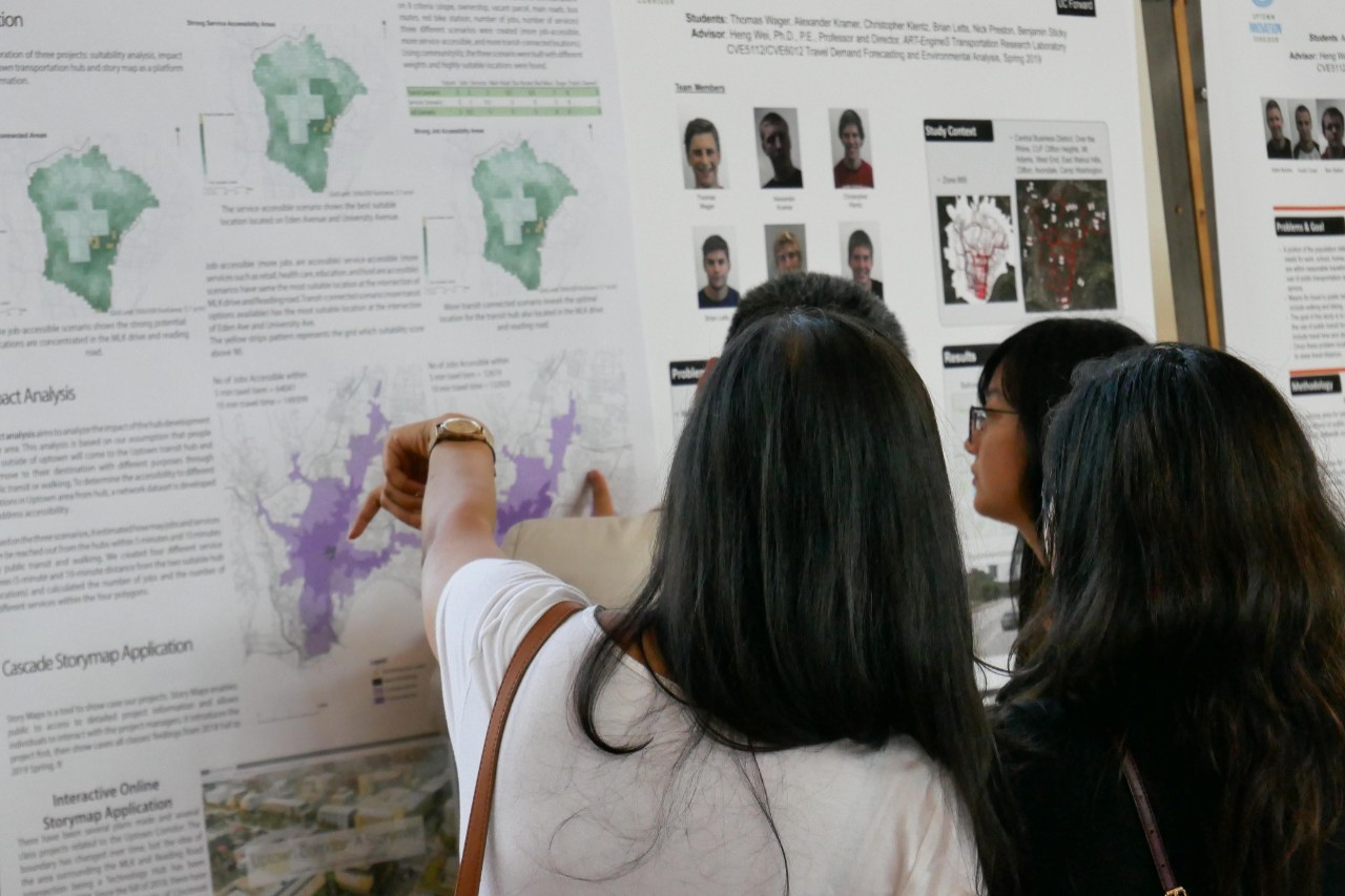 students point to posters on wall