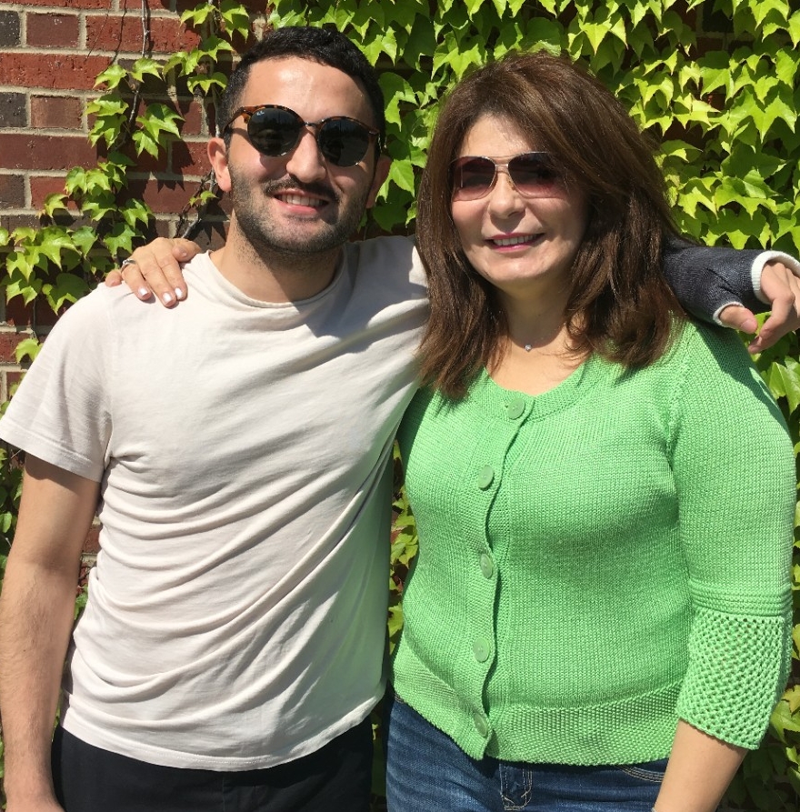 Rash and his mother Rana pose in front of a brick wall covered in ivy.
