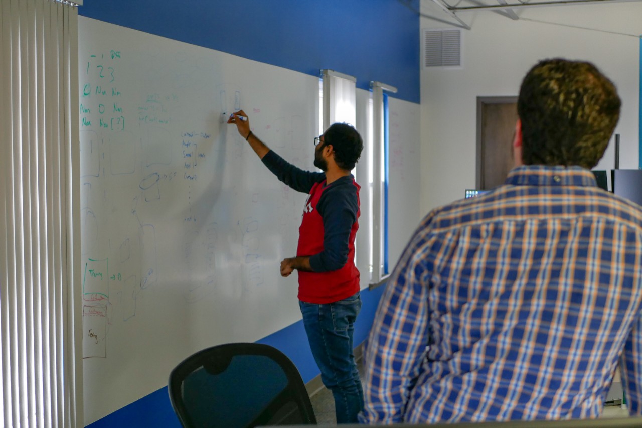 worker writing on dry erase board