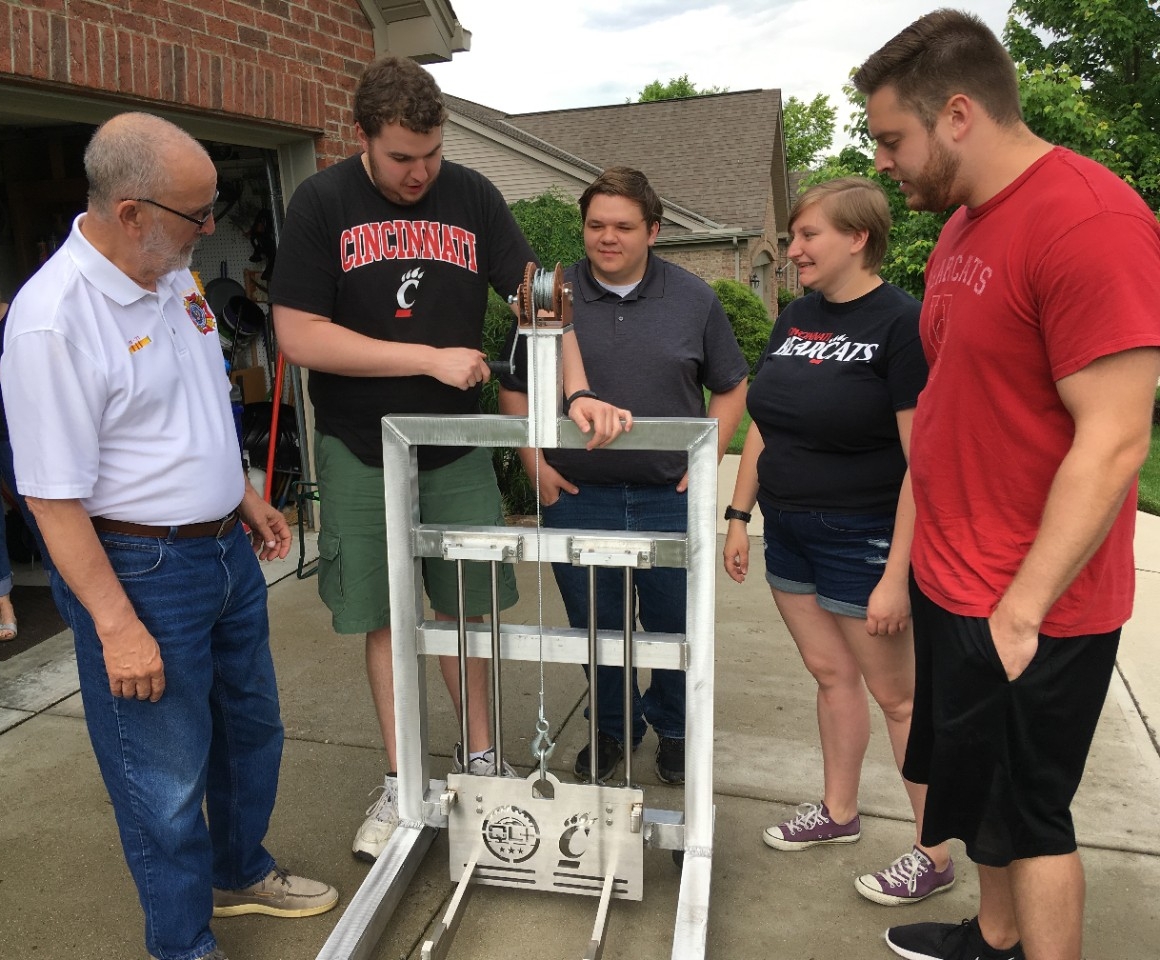 UC students explain the features of the lift to veteran Mike Donnelly in his driveway.