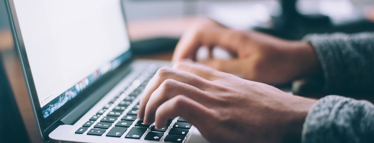 Person typing on laptop.