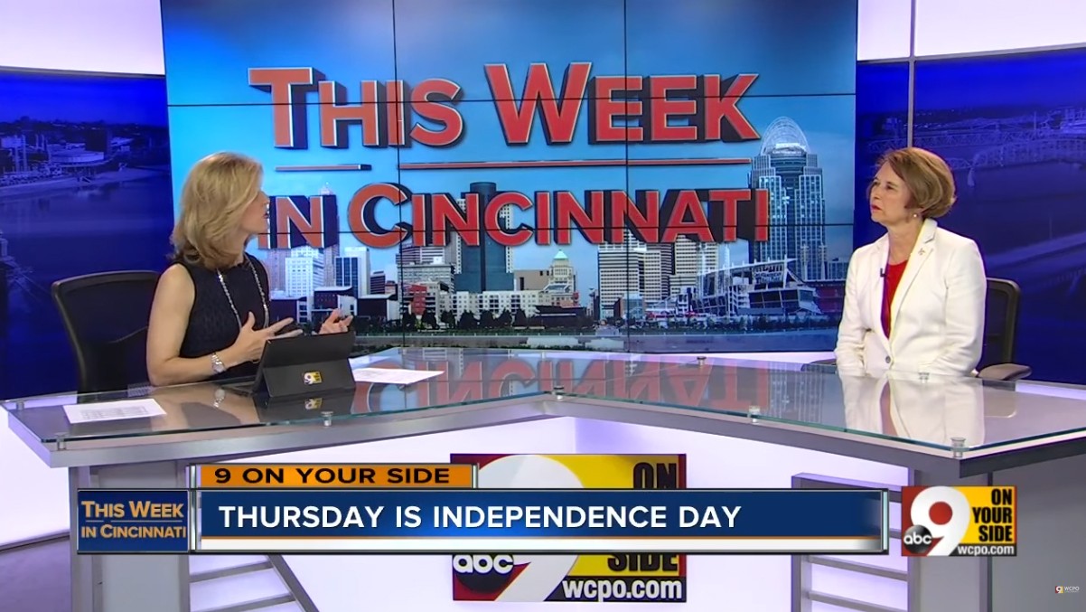 Two people sitting at a news desk in a news studio