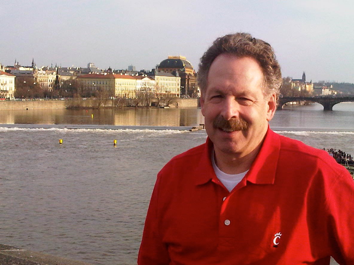 Larry Gales stands in front of a waterway with Prague Castle in the background