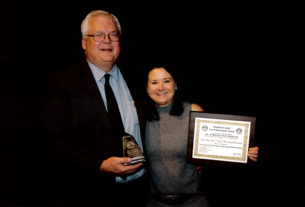 UCPD Police Chief Maris Herold stands holding an award from the Hamilton County Police Association with UC Public Safety Director James Whalen.
