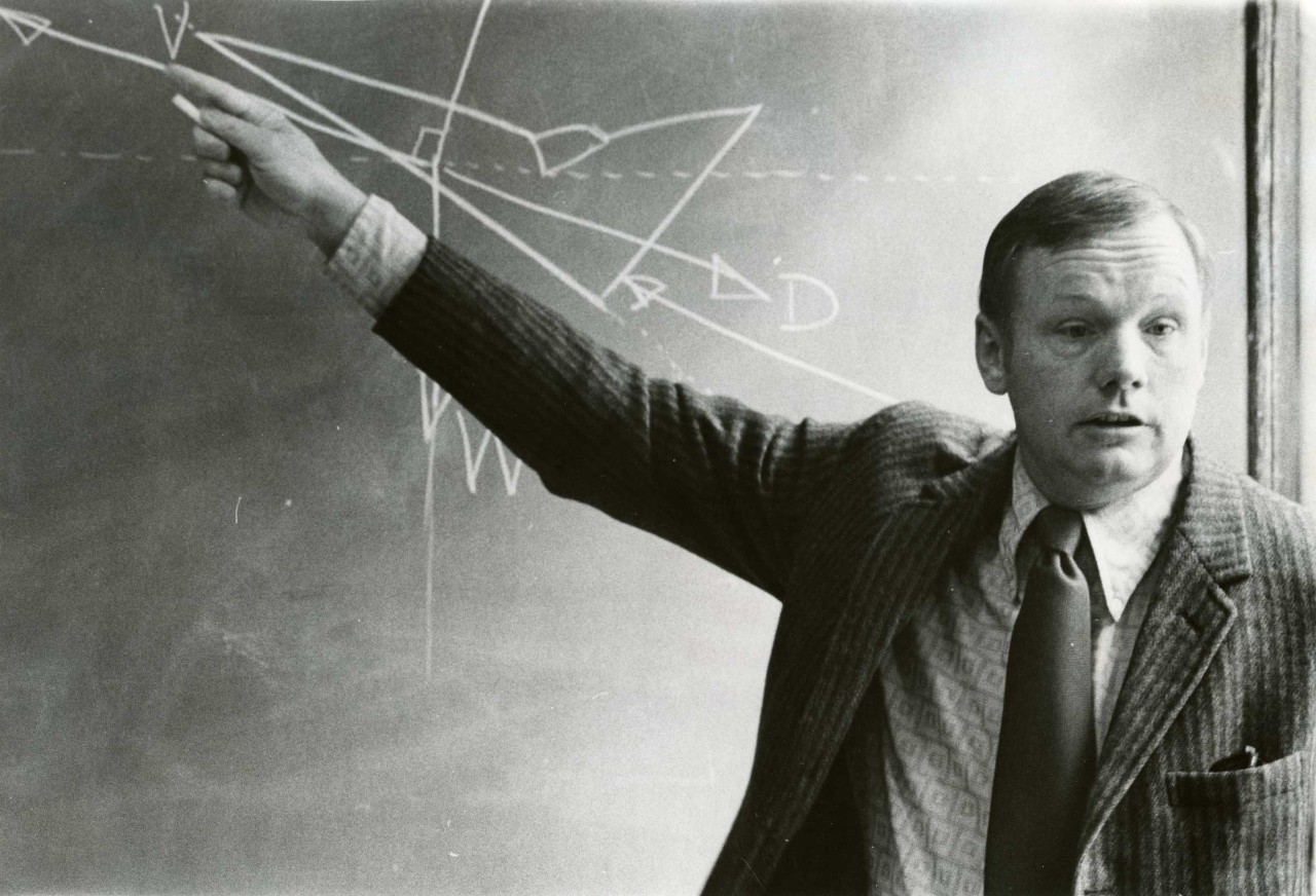 Neil Armstrong stands at a chalkboard.