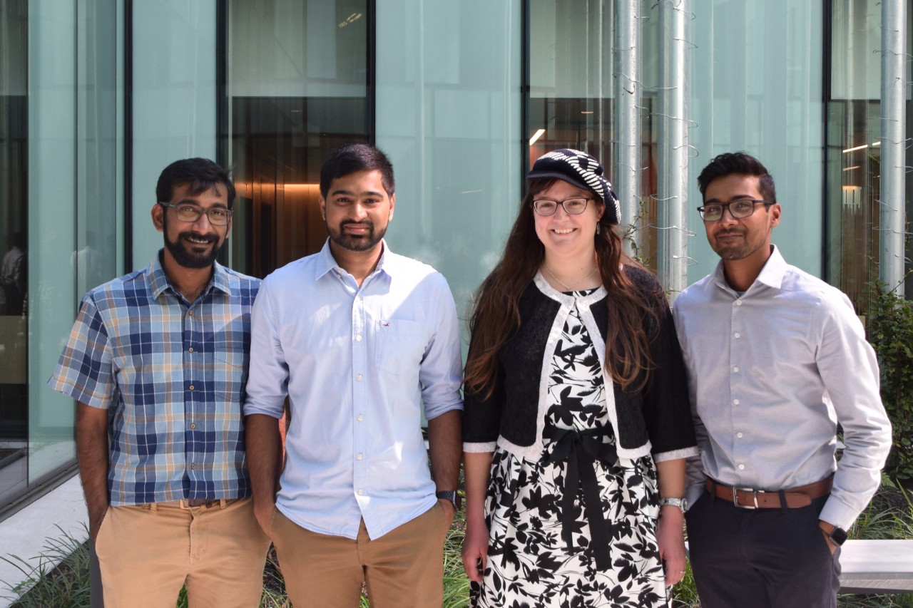 The four members of the Graduate Student Government stand together in a courtyard.