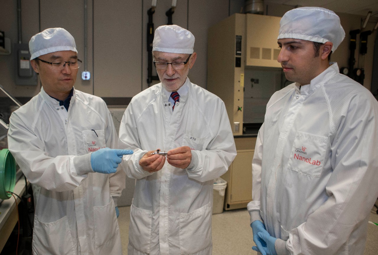 Left to right Daewoo Han, PhD student, UC professor Andrew Steckl, PhD and Serdar Tort, PhD talk in professor Andrew Steckl’s lab at Rhodes Hall. UC/ Joseph Fuqua II